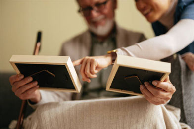 Elderly couple sharing memories through picture frames.