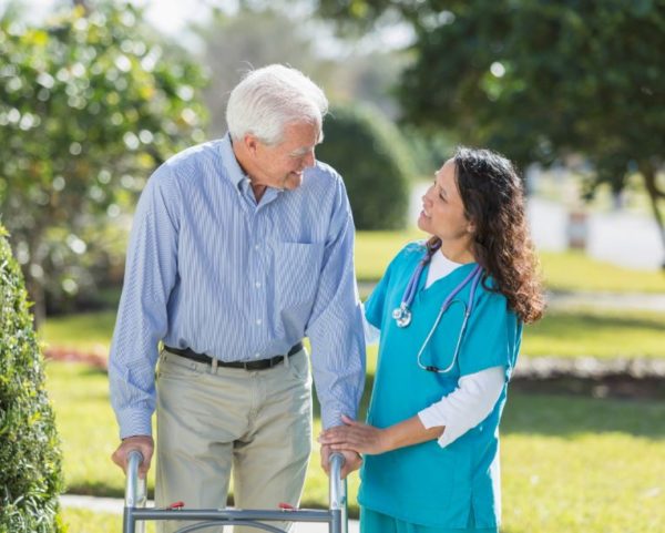 nurse helping rehab patient outside rehab facility