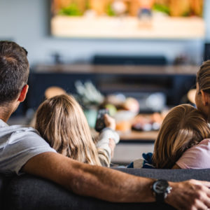 Family on couch watching television