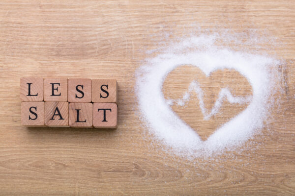 Less Salt Near Heart Shape With Heartbeat On Wooden Desk